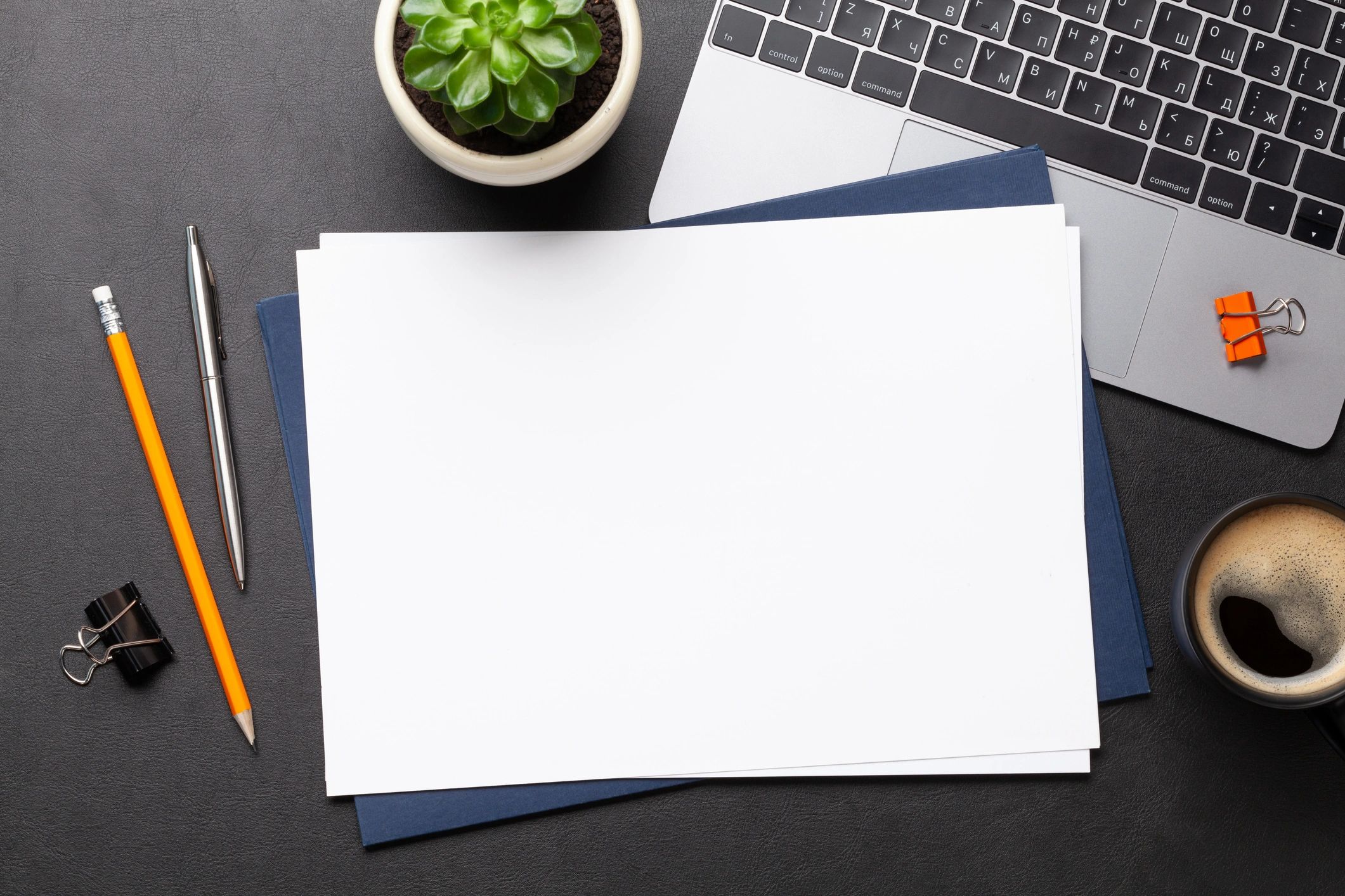 Workspace with blank paper and computer for academic editing